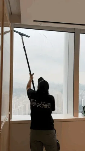 고층 창을 폴대로 닦는 수영클린 작업자