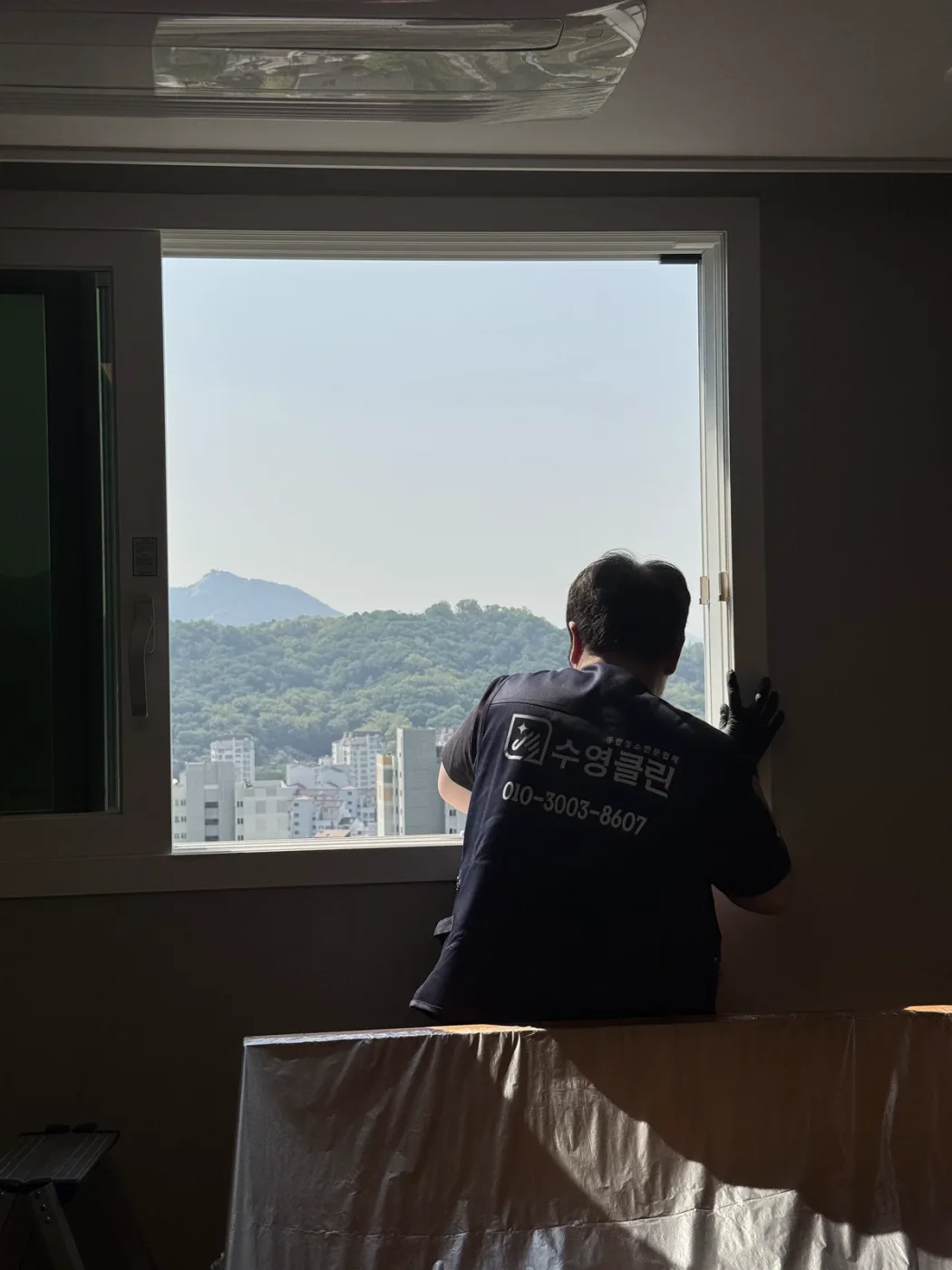 창문 유리를 닦는 수영클린 작업자