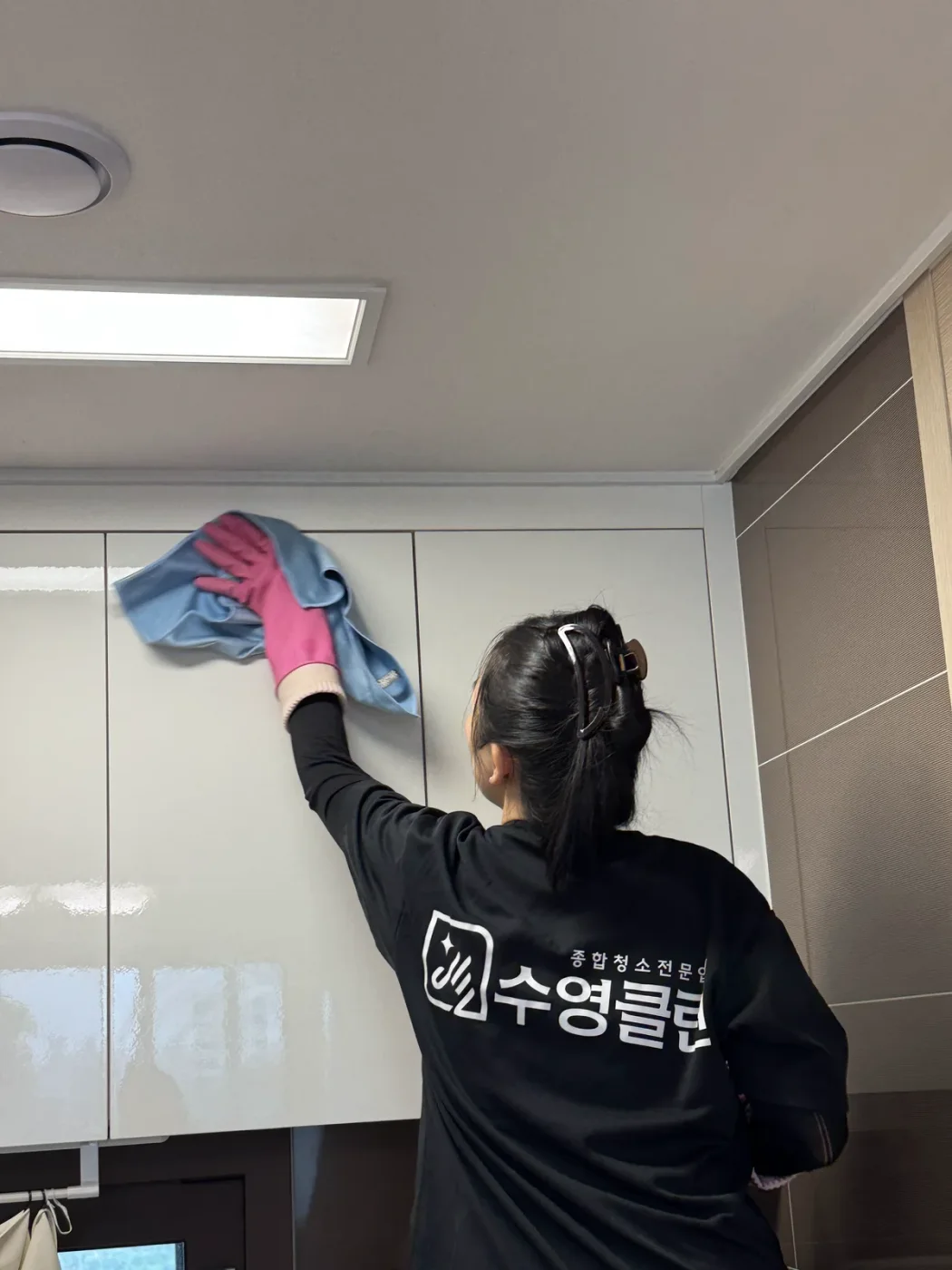 장갑을 끼고 붙박이장 문을 닦는 작업자