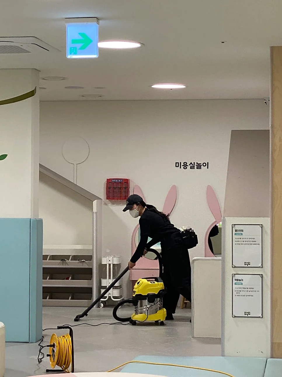 수유실 앞 바닥을 청소기로 미는 작업자